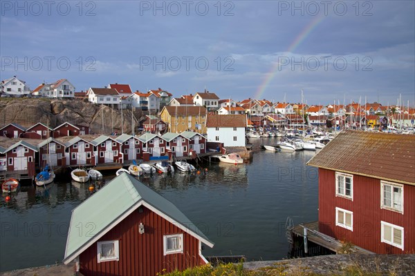 Colourful traditional fishing huts and boathouses along wooden pier at Smoegen