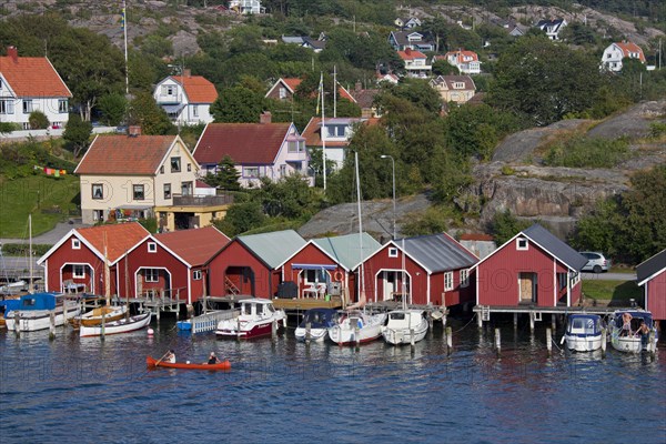 Red wooden boat huts in the harbour at Hamburgsund