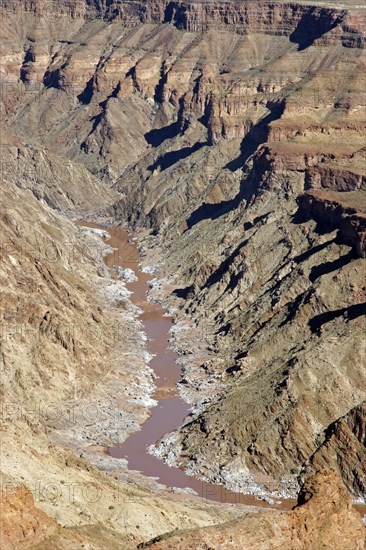 Water of stream flowing through the eroded rocks of the Fish River Canyon