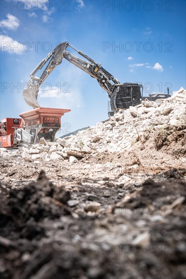 Black tracked excavator during demolition recycling on construction site