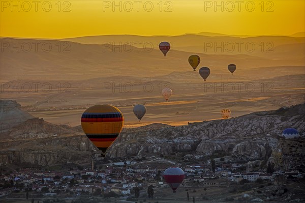 Hot air balloons flying over the town Goereme in Cappadocia at sunrise