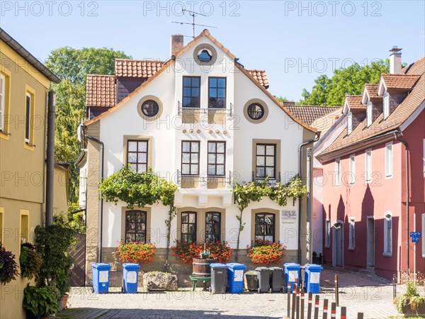 Rubbish bin in front of a house with flower decorations