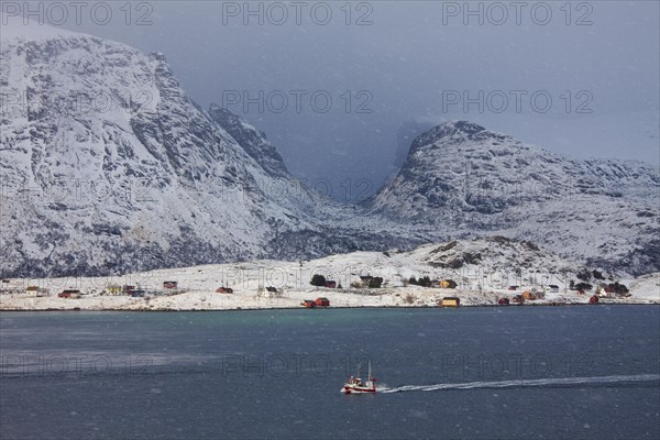 Fishing boat sailing through snowstorm in winter