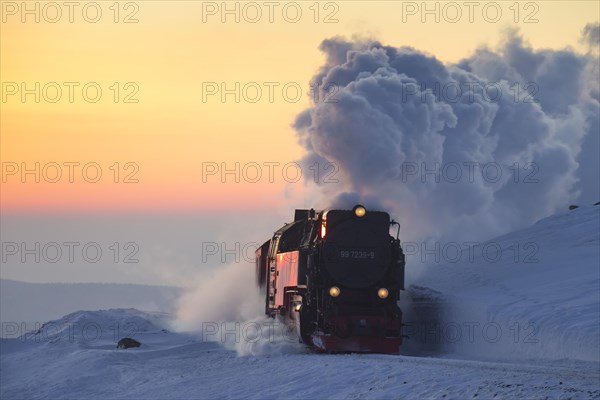 Steam train riding the Brocken Narrow Gauge railway line in the snow in winter at the Harz National park