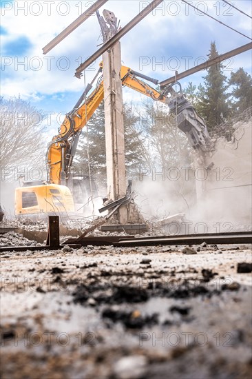 Yellow Liebherr crawler excavator recycling on demolition site