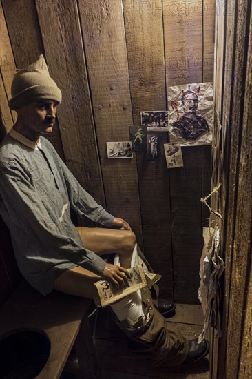 Diorama of British soldier sitting in dugout toilet of First World War One trench in the Memorial Museum Passchendaele 1917 at Zonnebeke