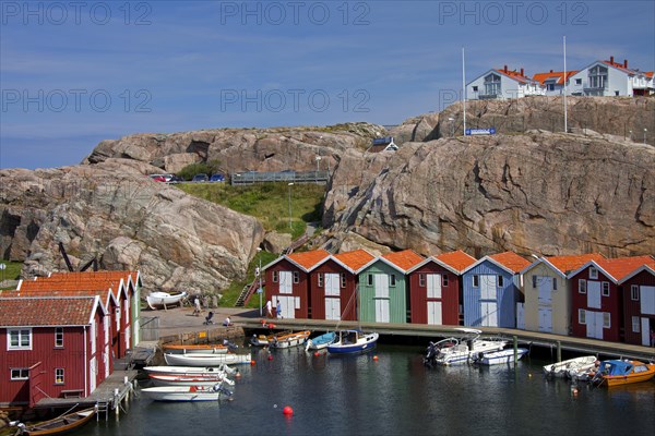 Colourful traditional fishing huts and boathouses along wooden pier at Smoegen