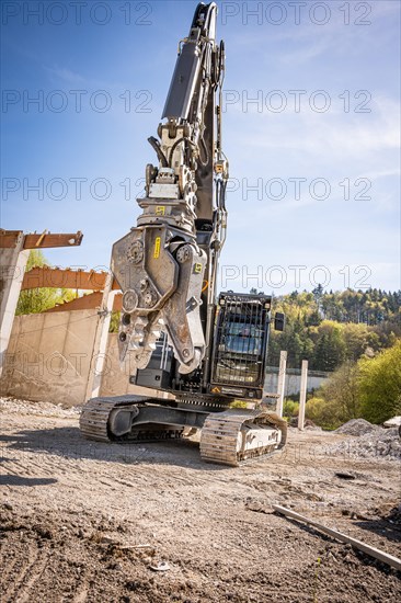 Black Liebherr crawler excavator with spreader recycling on demolition site