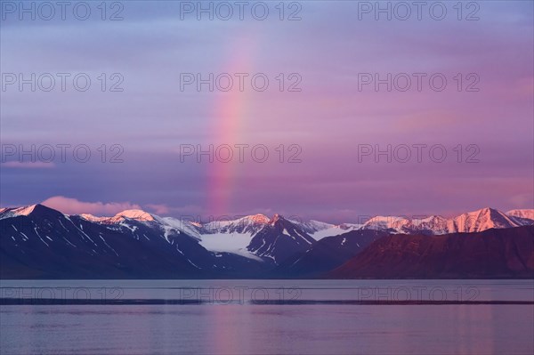 Rainbow over Liefdefjorden at sunset in summer