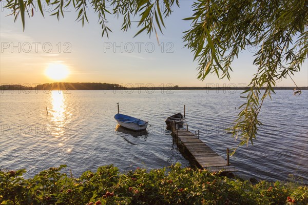 Wooden jetty with boats on Neustaedter Binnenwasser lake at Neustadt in Holstein