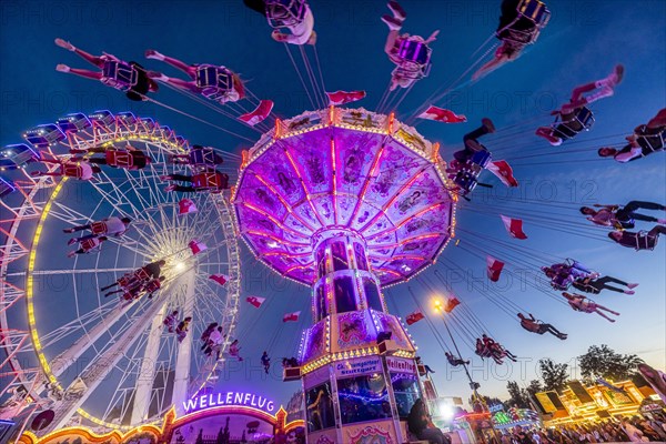 Ferris wheel and historic chain carousel in the evening