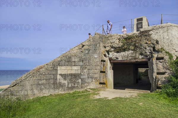 Tourists visiting the Fifth Engineer Special Brigade Memorial on top of German bunker at Omaha Beach