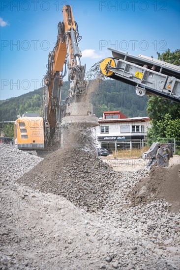 Yellow Liebherr crawler excavator recycling on demolition site