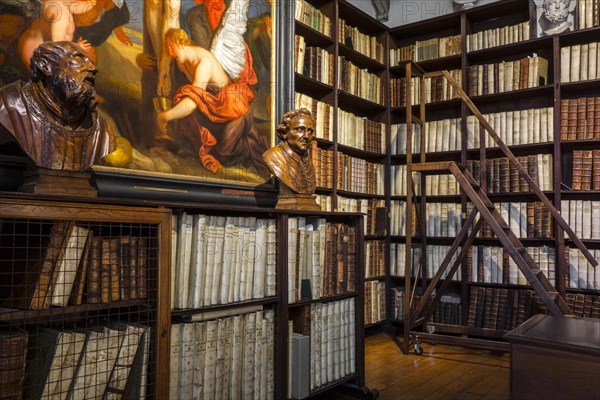 Bookshelves with old books in the 17th century Great Library at the Plantin-Moretus Museum