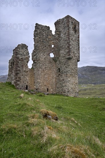 Tourists visiting 16th century Ardvreck Castle ruin at Loch Assynt in the Scottish Highlands