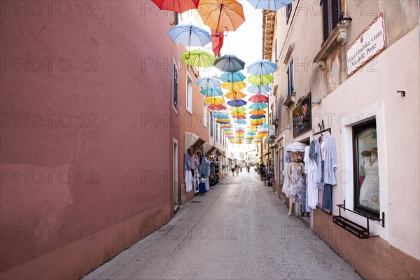 Alley with colourful umbrellas suspended over a street