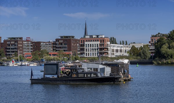 Illegally anchored houseboats in the Rummelsburg Bay with the residential houses on the Rummelsburg shore