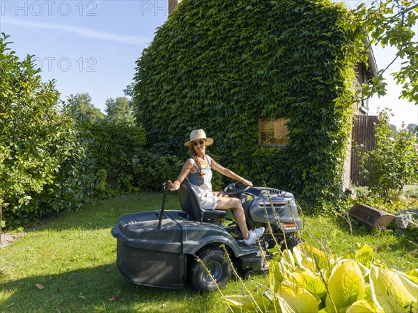 Woman driving lawn mower