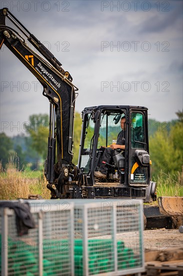 Black Yanmar Mini tracked excavator during earthworks for house construction on building site