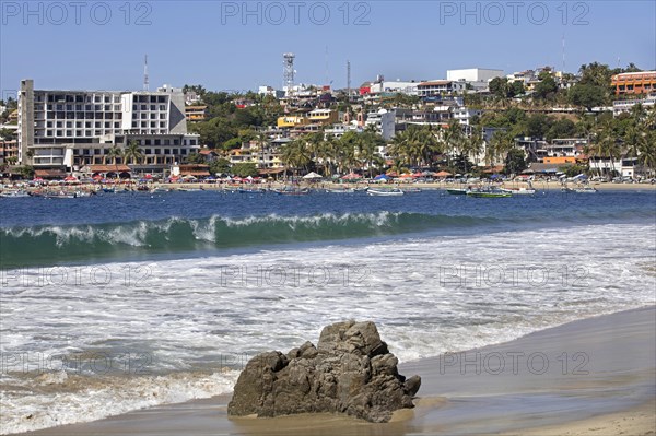 Tourists on sandy beach and hotels at Playa Principal near Puerto Escondido
