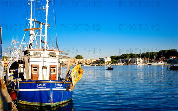 Fishing cutter in the fishing harbour of Travemuende with a view of Priewall