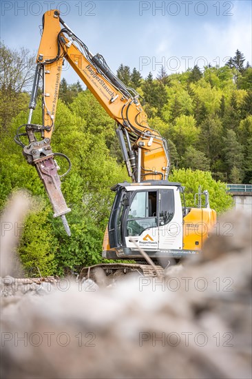 Yellow Liebherr crawler excavator with chisel recycling on demolition site