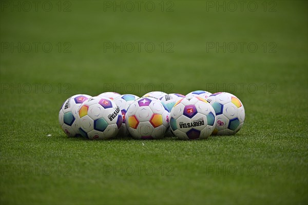 Adidas match balls Derbystar lie on grass