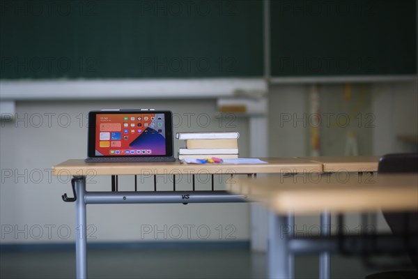 A digital device and books on a school desk as the summer holidays approach.Bavaria