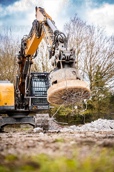 Yellow Liebherr crawler excavator with magnet recycling on demolition site
