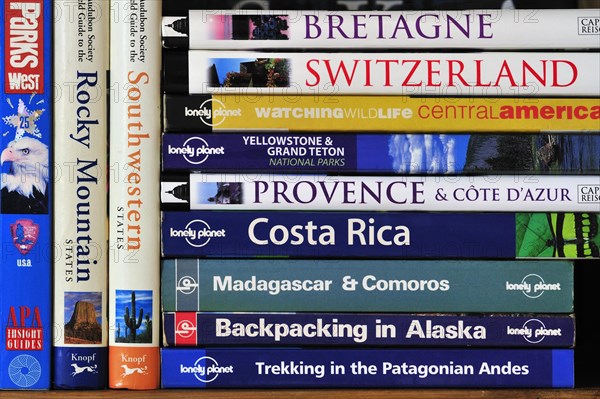 Collection of travel guides about worlwide holiday destinations on a bookshelf