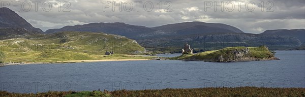 Calda House and the 16th century Ardvreck Castle ruins at Loch Assynt in the Highlands at sunset