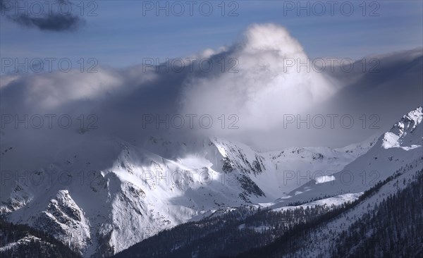 Snowstorm rolling in over the snow covered Alpine mountains in winter in the Swiss Alps at Wallis