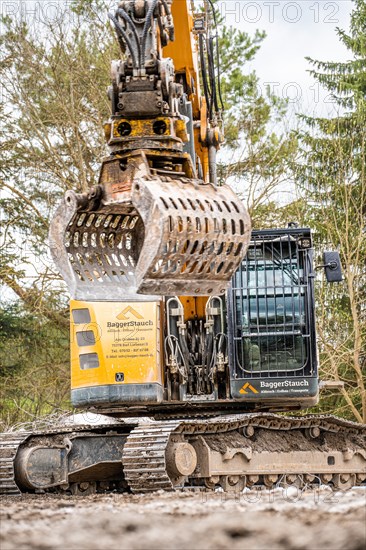 Yellow Liebherr crawler excavator recycling on demolition site