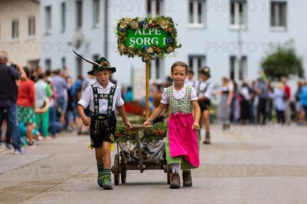 Alpine children pulling ladder wagons