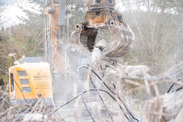 Yellow Liebherr crawler excavator recycling on demolition site