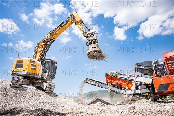 Yellow Liebherr crawler excavator with magnet recycling on demolition site