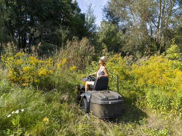 Woman driving lawn mower