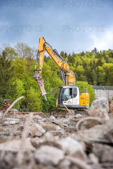 Yellow Liebherr crawler excavator recycling on demolition site