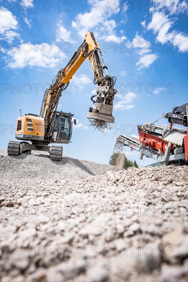 Yellow tracked excavator for demolition recycling on construction site