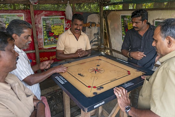 Indian man playing carrom board game