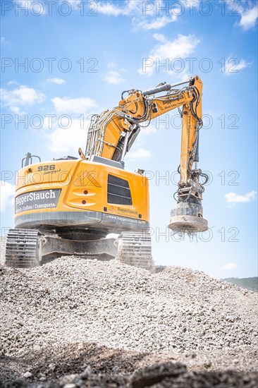 Yellow Liebherr crawler excavator with magnet recycling on demolition site