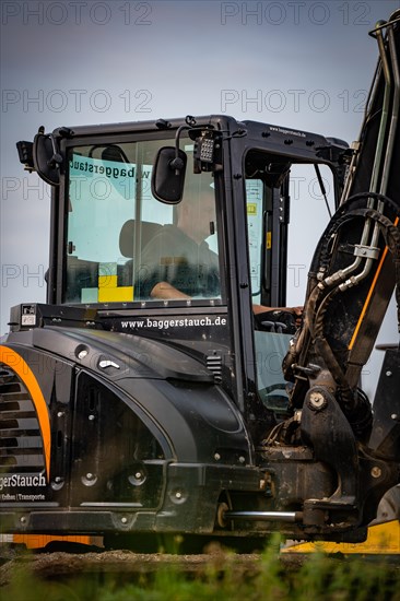 Black Yanmar Mini tracked excavator during earthworks for house construction on building site