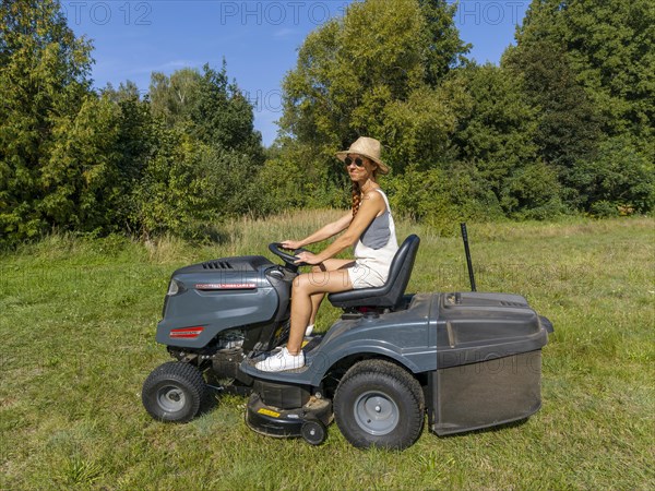 Woman driving lawn mower