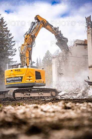 Yellow Liebherr crawler excavator recycling on demolition site