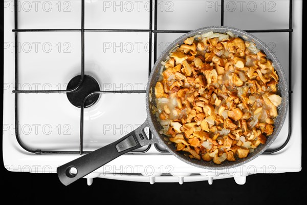 Frying chanterelle mushrooms with onion in a pan