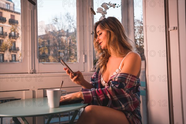 Lifestyle of a young blonde breakfast having breakfast next to the sale of his house. Dressed in underwear and pajamas