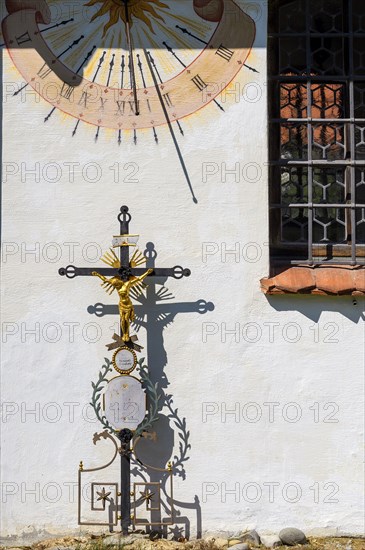 Facade with sundial and iron burial cross in the Swabian Open Air Museum