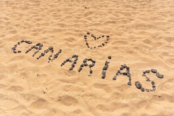 Canary name with black stones on the beach of the dunes of the Corralejo Natural Park