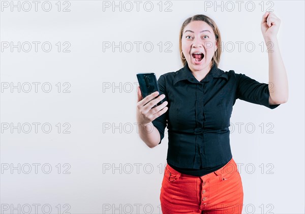 Winner happy young girl holding cell phone. Happy young woman celebrating with phone isolated. Happy people holding smartphone and celebrating