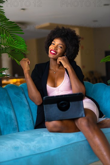 Young entrepreneur of black race and afro hair making a video call very happy